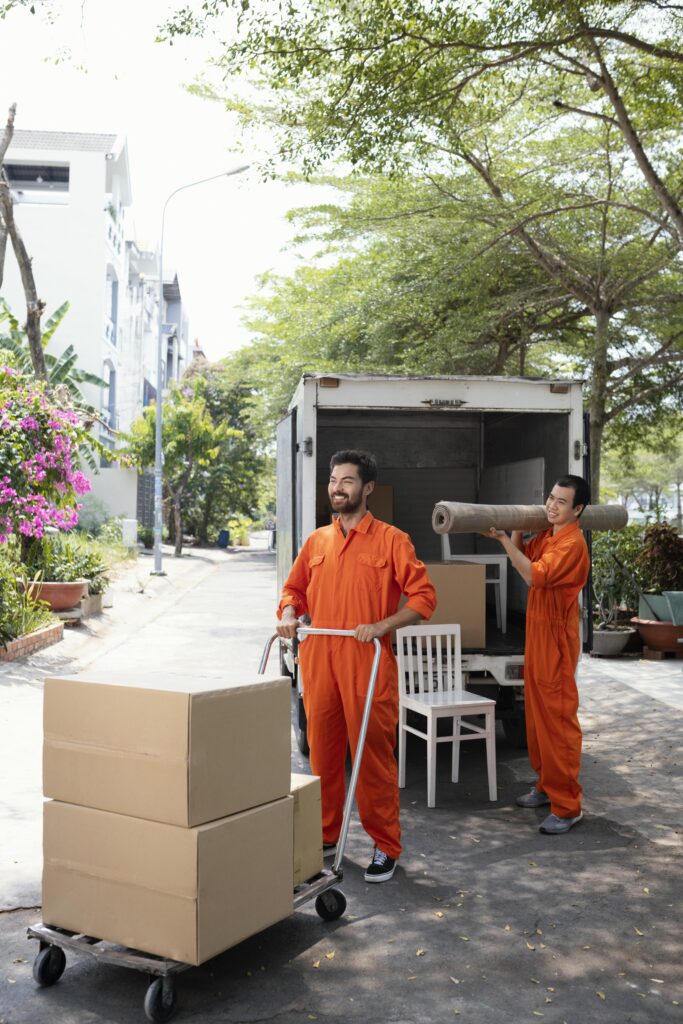 vertical shot young delivery men moving objects out car